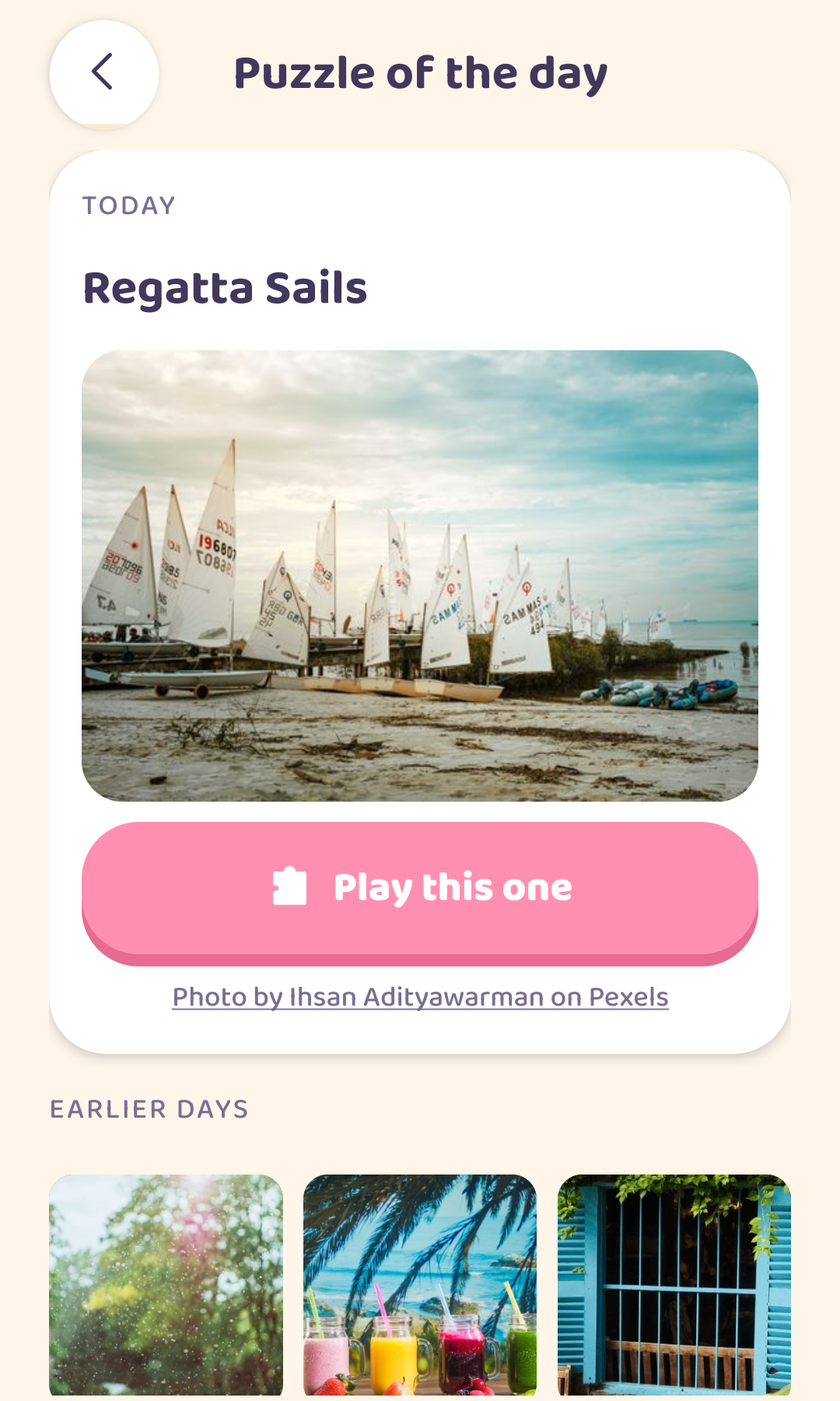 The puzzle-of-the-day screen, showing today's photograph of moored sailing dinghies with the photographer credited beneath it.